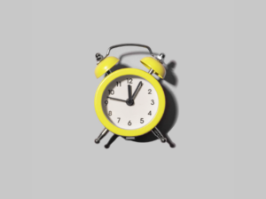 Photograph of a yellow vintage alarm bell clock in a great background.